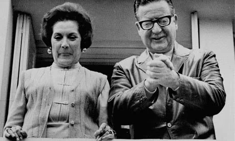 Salvador Allende dan istrinya, Hortensia Bussi de Allende, tersenyum dari jendela rumah mereka di Santiago pada tahun 1970. Hasil otopsi memastikan bahwa Allende bunuh diri dan menjadi martir perjuangan rakyat Chili. Foto: AP