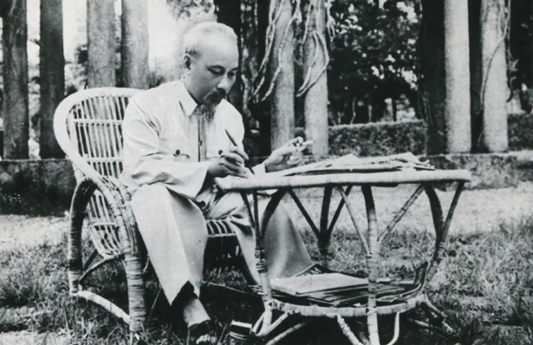 Hồ Chí Minh (1890-1969) duduk di sebuah meja di taman Istana Kepresidenan, Hanoi, Vietnam, 1957