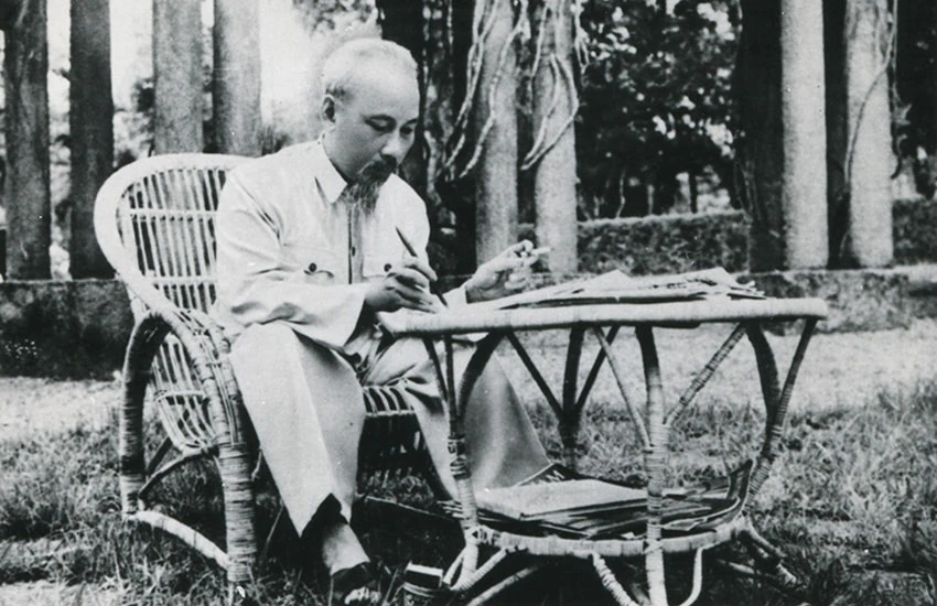 Hồ Chí Minh (1890-1969) duduk di sebuah meja di taman Istana Kepresidenan, Hanoi, Vietnam, 1957